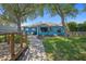 Turquoise home with brick path, large windows, and a view of the well-kept lawn and trees at 1363 Wayne Ave, New Smyrna Beach, FL 32168