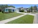 Landscaped front yard with a well-kept lawn complements this cozy, light-blue home at 1363 Wayne Ave, New Smyrna Beach, FL 32168