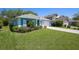 Delightful home showcasing a lush front lawn and colorful blue accents for added charm at 1363 Wayne Ave, New Smyrna Beach, FL 32168