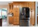 Kitchen boasts wood cabinets, stainless steel refrigerator, and tiled floors at 1363 Wayne Ave, New Smyrna Beach, FL 32168