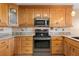 Well-lit kitchen featuring wooden cabinetry, granite countertops, and stainless steel appliances at 1363 Wayne Ave, New Smyrna Beach, FL 32168
