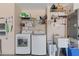 Functional laundry area with modern washer, dryer, utility sink and shelving at 1363 Wayne Ave, New Smyrna Beach, FL 32168