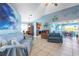 Inviting living room featuring tile flooring, coastal decor, and sliders leading to the lanai at 1363 Wayne Ave, New Smyrna Beach, FL 32168
