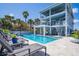Beautiful backyard oasis with a large pool, lounge chairs, and tropical landscaping at 1373 N Atlantic Ave, New Smyrna Beach, FL 32169