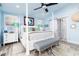 Bedroom featuring a four-poster bed, ensuite bathroom, and tranquil blue decor with ocean view at 1373 N Atlantic Ave, New Smyrna Beach, FL 32169