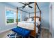 Light and airy bedroom featuring a four-poster bed and large window with scenic views, creating a tranquil atmosphere at 1373 N Atlantic Ave, New Smyrna Beach, FL 32169