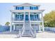 Two-story home with blue shutters and charming front porch features seating and brick driveway at 1373 N Atlantic Ave, New Smyrna Beach, FL 32169