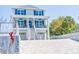 Two-story home with blue shutters and a charming front porch with seating and a brick driveway at 1373 N Atlantic Ave, New Smyrna Beach, FL 32169