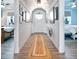 Inviting hallway with wood floors and a decorative rug leading to bedrooms on either side at 1373 N Atlantic Ave, New Smyrna Beach, FL 32169