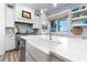 Kitchen island with a large sink, white marble countertops, ocean views, and modern appliances at 1373 N Atlantic Ave, New Smyrna Beach, FL 32169
