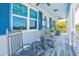 Front porch with rocking chairs, wood flooring, blue shutters, and views of lush greenery at 1373 N Atlantic Ave, New Smyrna Beach, FL 32169
