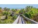 A wooden walkway winds through lush greenery, leading to the beach and ocean at 1373 N Atlantic Ave, New Smyrna Beach, FL 32169