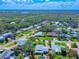 Picturesque aerial view of a residential area featuring well-maintained homes surrounded by lush greenery and a marsh landscape beyond at 16 Hillside Dr, New Smyrna Beach, FL 32169
