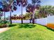 Large, lush backyard with a well-maintained lawn, palms and privacy fence at 16 Hillside Dr, New Smyrna Beach, FL 32169