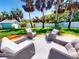 Outdoor patio features seating area, lush lawn, palms and small shed at 16 Hillside Dr, New Smyrna Beach, FL 32169