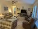 Inviting living room with tile floors, a ceiling fan, and beach-themed decor at 1629 Travelers Palm Dr, Edgewater, FL 32132