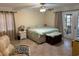 Serene bedroom features a neutral palette, ceiling fan, and a private door to a patio at 1629 Travelers Palm Dr, Edgewater, FL 32132