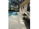The covered pool patio offers outdoor seating, a bean bag chair, and privacy at 1629 Travelers Palm Dr, Edgewater, FL 32132