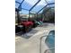 Inviting pool patio features an outdoor grill, bar, lounge chairs, and a screened enclosure at 1629 Travelers Palm Dr, Edgewater, FL 32132