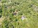 Overhead shot reveals a beautiful property with a pool and private pond, all nestled within a dense, leafy forest at 1663 Hideaway Ln, Edgewater, FL 32132