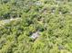 Aerial shot showcasing a private home with a pool, tucked away amidst dense trees, ensuring ultimate seclusion at 1663 Hideaway Ln, Edgewater, FL 32132