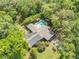 Aerial view of a beautiful home with a sparkling pool surrounded by mature trees at 1663 Hideaway Ln, Edgewater, FL 32132