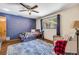 Bedroom featuring a striking blue accent wall, ceiling fan and large window at 1663 Hideaway Ln, Edgewater, FL 32132