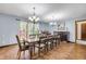 Elegant dining area with wood-style tile, chandeliers, large windows, seamlessly blending style and comfort at 1663 Hideaway Ln, Edgewater, FL 32132
