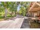 View of the property's driveway, highlighting mature trees, landscaping, and additional building at 1663 Hideaway Ln, Edgewater, FL 32132