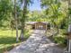 Attractive home exterior with stone accents, lush trees, and a lengthy driveway leading to a serene setting at 1663 Hideaway Ln, Edgewater, FL 32132