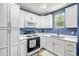Well-lit kitchen featuring white cabinets, modern appliances, and a functional layout at 1663 Hideaway Ln, Edgewater, FL 32132
