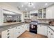 Charming kitchen with white cabinets, brick backsplash, wine rack, and an opening to the dining area at 1663 Hideaway Ln, Edgewater, FL 32132