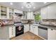Bright kitchen showcasing white cabinets, brick backsplash, stainless steel dishwasher and hardwood floors at 1663 Hideaway Ln, Edgewater, FL 32132