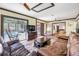 Living room features sliding glass doors to the backyard pool area, comfortable seating, and wood floors at 1663 Hideaway Ln, Edgewater, FL 32132