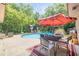 Inviting pool area with outdoor seating, a patio umbrella, and lush landscaping at 1663 Hideaway Ln, Edgewater, FL 32132