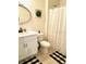 Bright bathroom with a white vanity, decorative mirror, and a shower with a curtain at 181 Caryota Ct, New Smyrna Beach, FL 32168