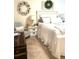 Comfortable bedroom featuring a white bed, decorative wall wreath, and a cozy armchair at 181 Caryota Ct, New Smyrna Beach, FL 32168