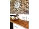 Close-up of a charming brick wall adorned with decorative clock and a wood countertop at 181 Caryota Ct, New Smyrna Beach, FL 32168