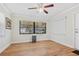 Bright living room featuring wood-look floors, large windows, and a ceiling fan at 1855 Pine Tree Dr, Edgewater, FL 32141