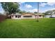 Expansive backyard with lush lawn and a glimpse of a cozy screened-in patio, perfect for outdoor relaxation at 1868 Pine Tree Dr, Edgewater, FL 32141