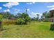 Fenced backyard features lush green grass, and partial view of the pool at 1905 Pine Tree Dr, Edgewater, FL 32141