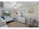 Cozy bedroom features a ceiling fan, white dresser, and a window that provides plenty of natural light at 1905 Pine Tree Dr, Edgewater, FL 32141