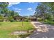 Traditional brick home with a well-maintained lawn and a long driveway leading to the garage at 1905 Pine Tree Dr, Edgewater, FL 32141