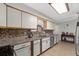 Stylish kitchen with white cabinets, stainless steel appliances, and a decorative backsplash at 1905 Pine Tree Dr, Edgewater, FL 32141
