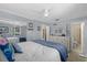 Bright main bedroom features blue accent wall, white furniture, and access to an ensuite bathroom at 1905 Pine Tree Dr, Edgewater, FL 32141