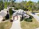 Aerial view showcases a single-story home with a two-car garage, well-kept lawn, and established landscaping at 1918 Whisperwood Way # 10, Port Orange, FL 32128