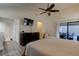 Bright bedroom with neutral walls, wood-look floors, ceiling fan, and sliding glass doors to the patio at 1918 Whisperwood Way # 10, Port Orange, FL 32128