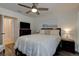 Comfortable bedroom features a queen bed, ceiling fan, mounted television, and art that complements the space at 1918 Whisperwood Way # 10, Port Orange, FL 32128