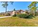 Single-story home with lush green lawn, mature landscaping, and a driveway leading to a two-car garage at 1918 Whisperwood Way # 10, Port Orange, FL 32128