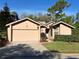 Charming single-story home featuring a two-car garage, well-maintained lawn, and beautiful landscaping at 1918 Whisperwood Way # 10, Port Orange, FL 32128